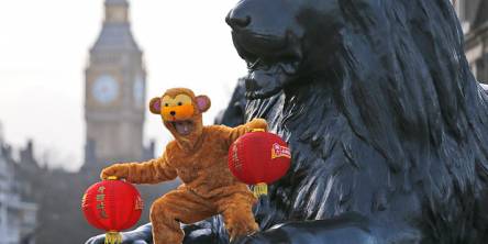 a person with a monkey costume on trafalgar square lions celebrating chinese new year